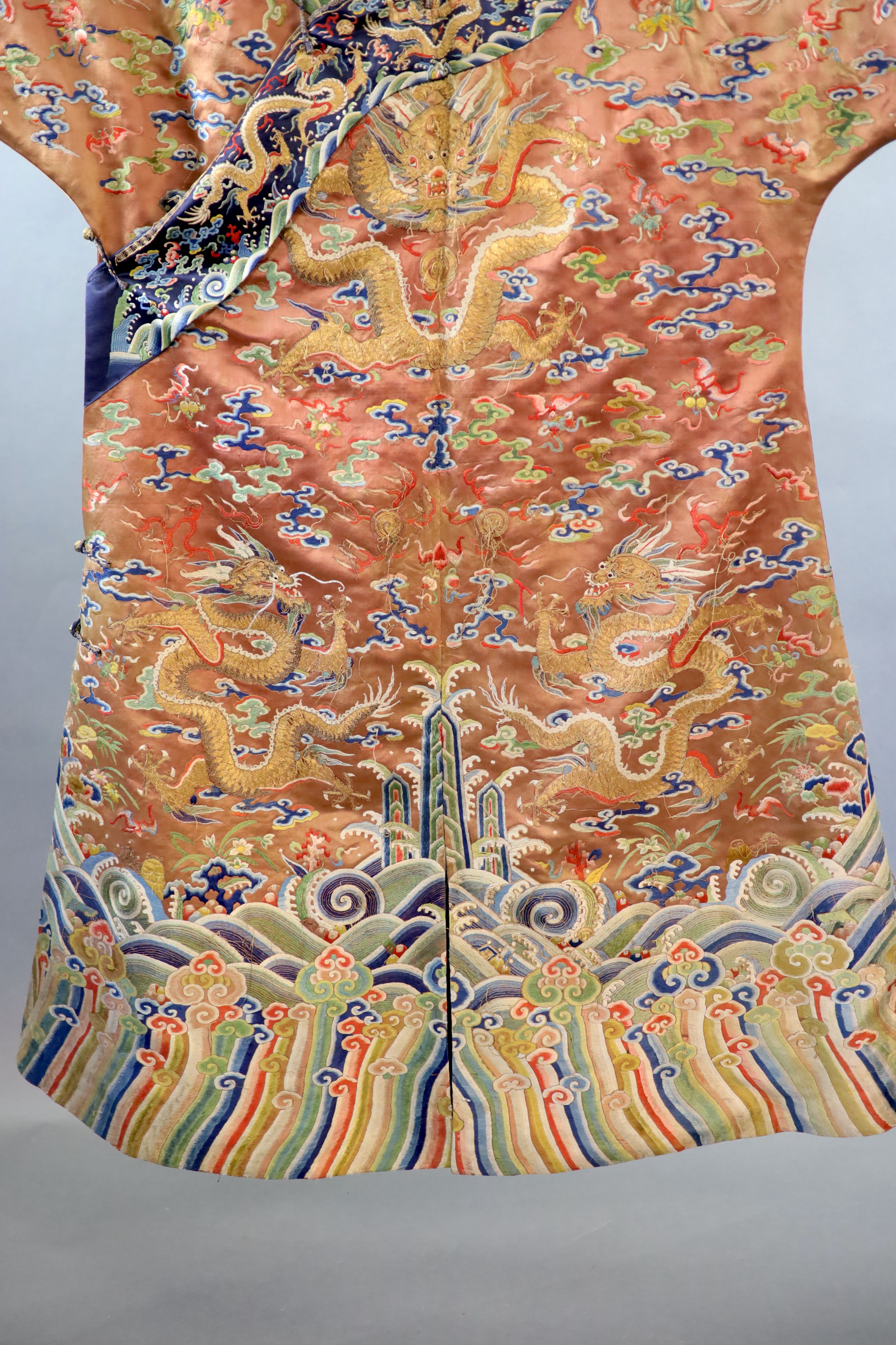 A Chinese apricot embroidered silk ‘dragon’ formal court robe, jifu, late Qing Dynasty, 131cm long, some alterations